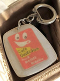 Porte-clés publicitaire vintage Café Quotidien France rétro, sourire rouge