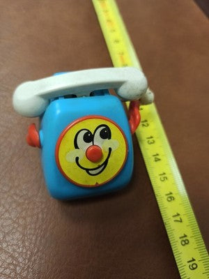 Téléphone jouet vintage Tomy 1978 bleu à remontoir, visage souriant rétro