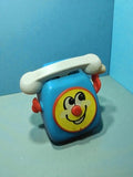 Téléphone jouet vintage Tomy 1978 bleu à remontoir, visage souriant rétro