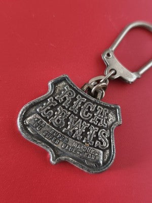 Ancien porte-clés publicitaire vintage Rica Lewis métal forme blason rétro
