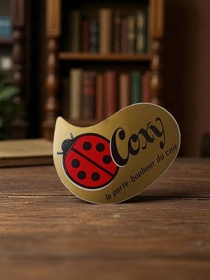 Autocollant publicitaire Coxy vintage doré coccinelle rétro déco cuir