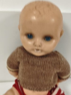 Poupée ancienne à yeux bleus, corps articulé, tenue tricotée brune