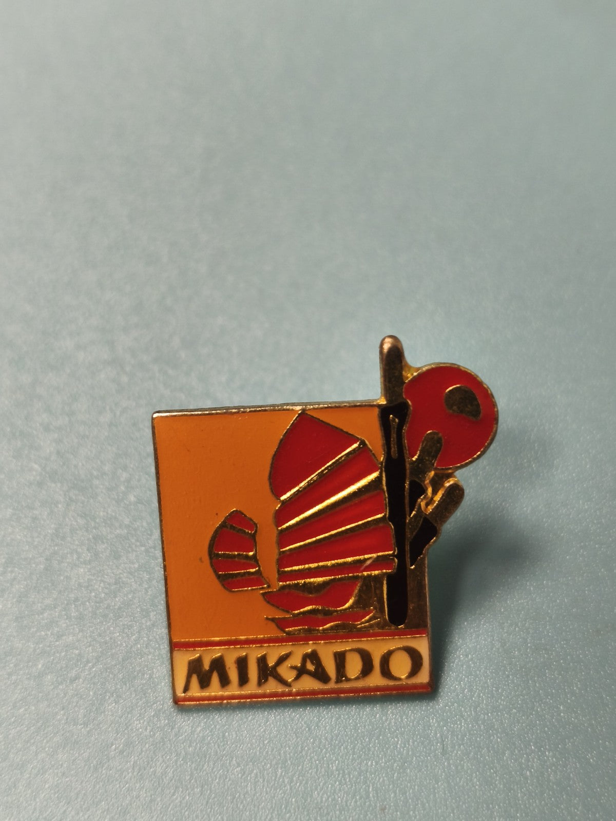 Pin's vintage Mikado carré émaillé orange rouge, collection badge ancien