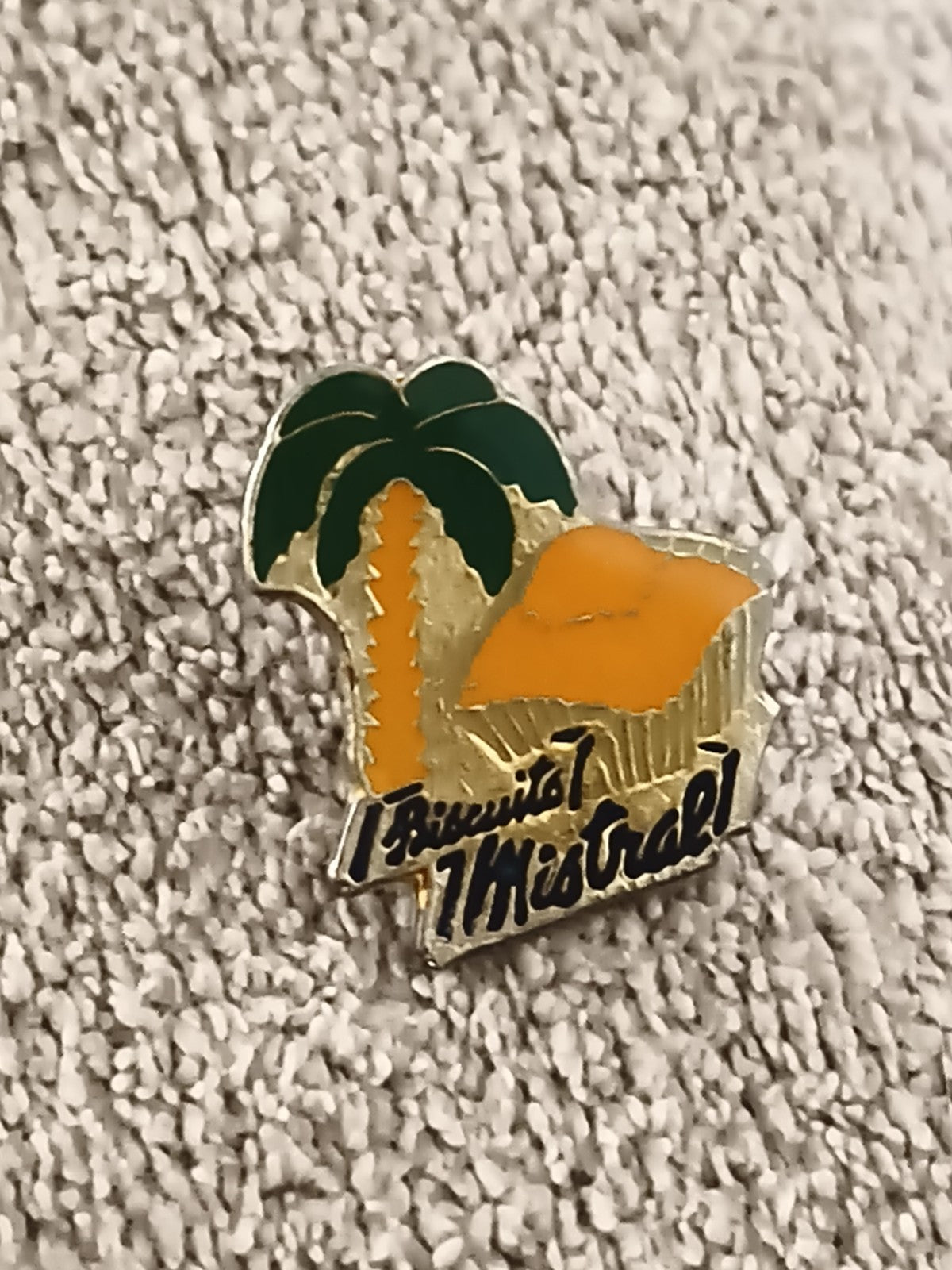 Pin's publicitaire vintage Biscuit Mistral, émaillé, palmier orange rétro