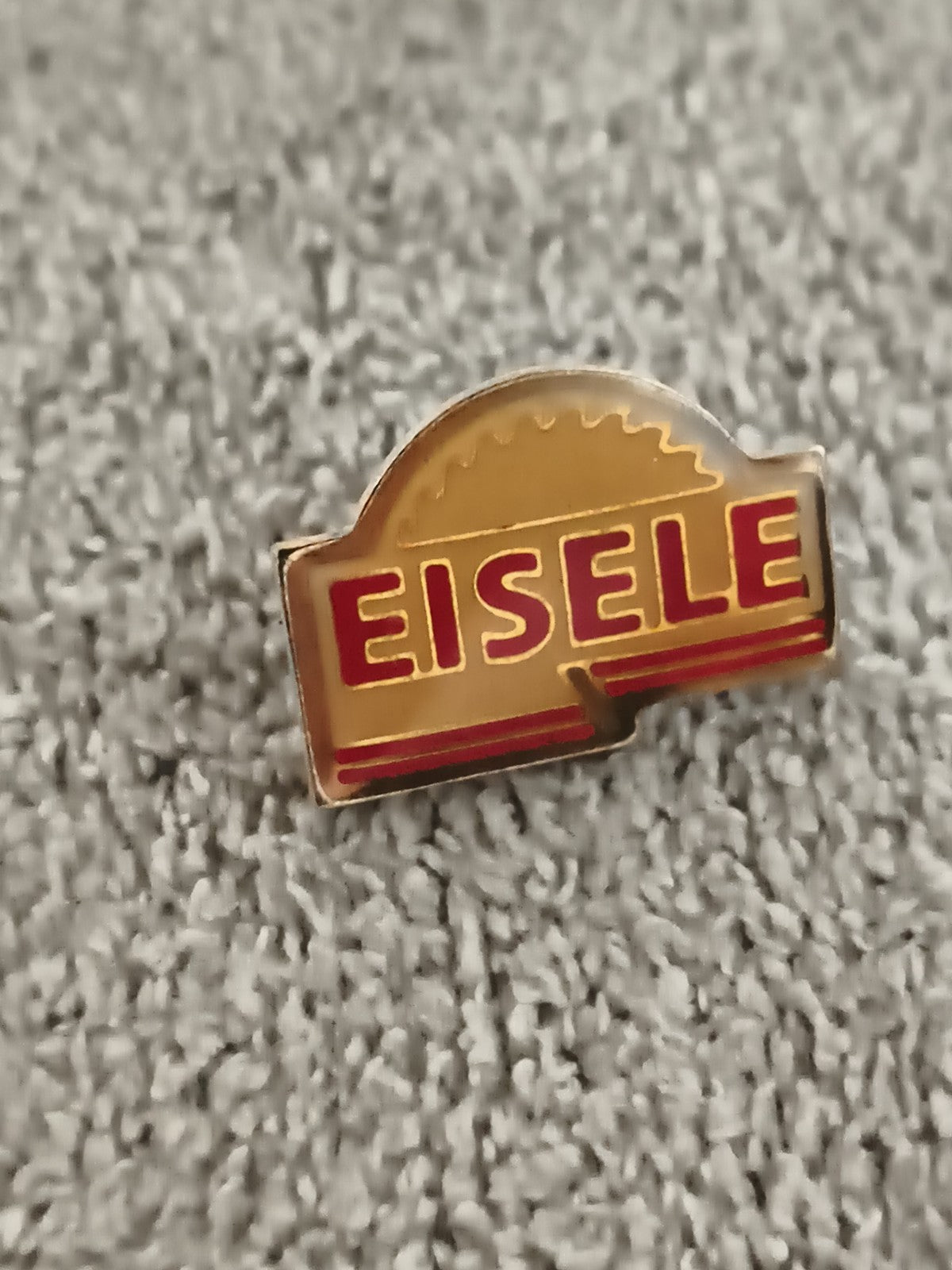 Pin's publicitaire EISELE vintage, logo scie circulaire, finition dorée (Ref 11)