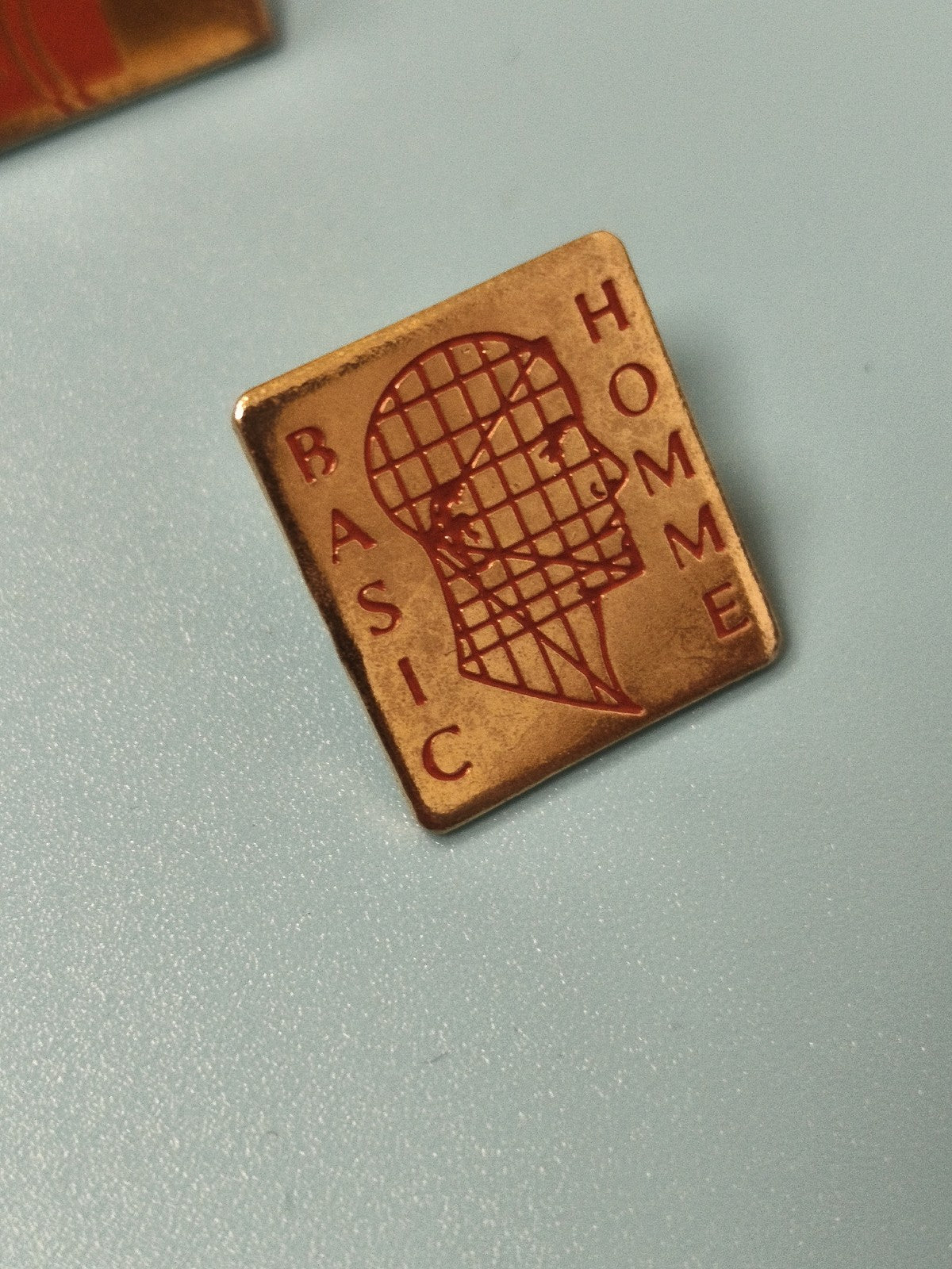 Vintage pin's carré BASIC HOMME doré motif tête géométrique ancien rare