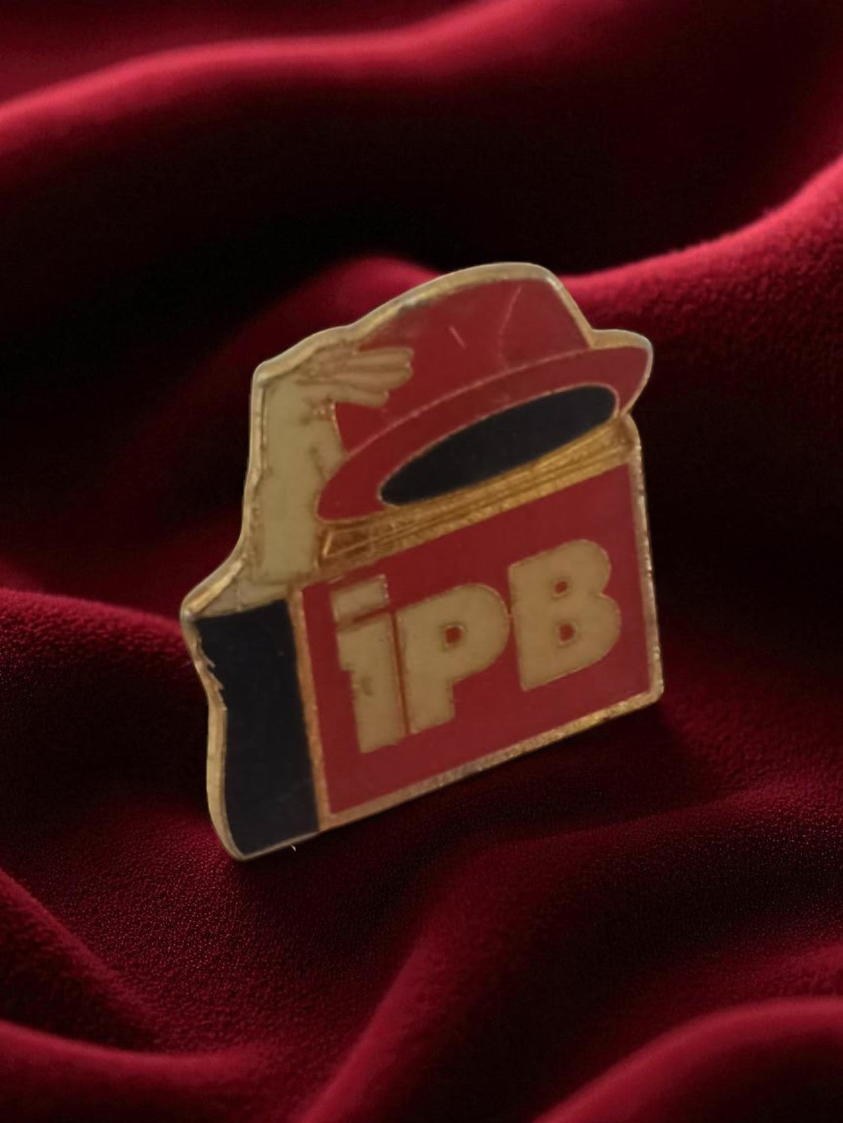Pin's publicitaire ancien IPB vintage badge rétro rouge main chapeau