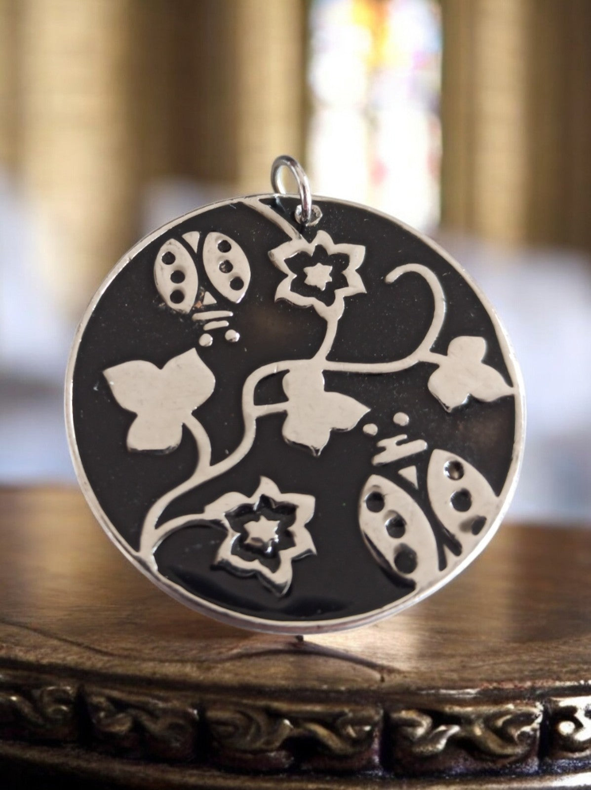 Pendentif rond vintage créateur motif papillons fleurs noir argenté design