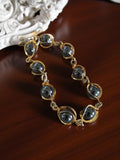 Bracelet vintage plaqué or perles grises style rétro élégant