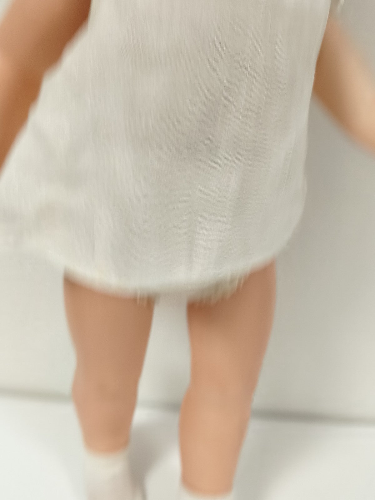 Ancienne poupée blonde aux yeux bleus, robe blanche et corps articulé