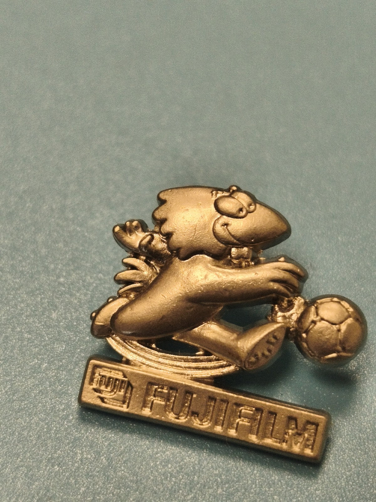 Pin's vintage Fujifilm mascotte football doré, collection publicitaire ancien