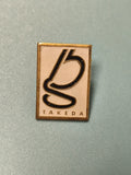 Pin's vintage Takeda rectangulaire logo noir et doré collection rare