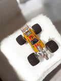 Voiture miniature vintage jaune, roues larges, déco lion, jouet rétro ancien