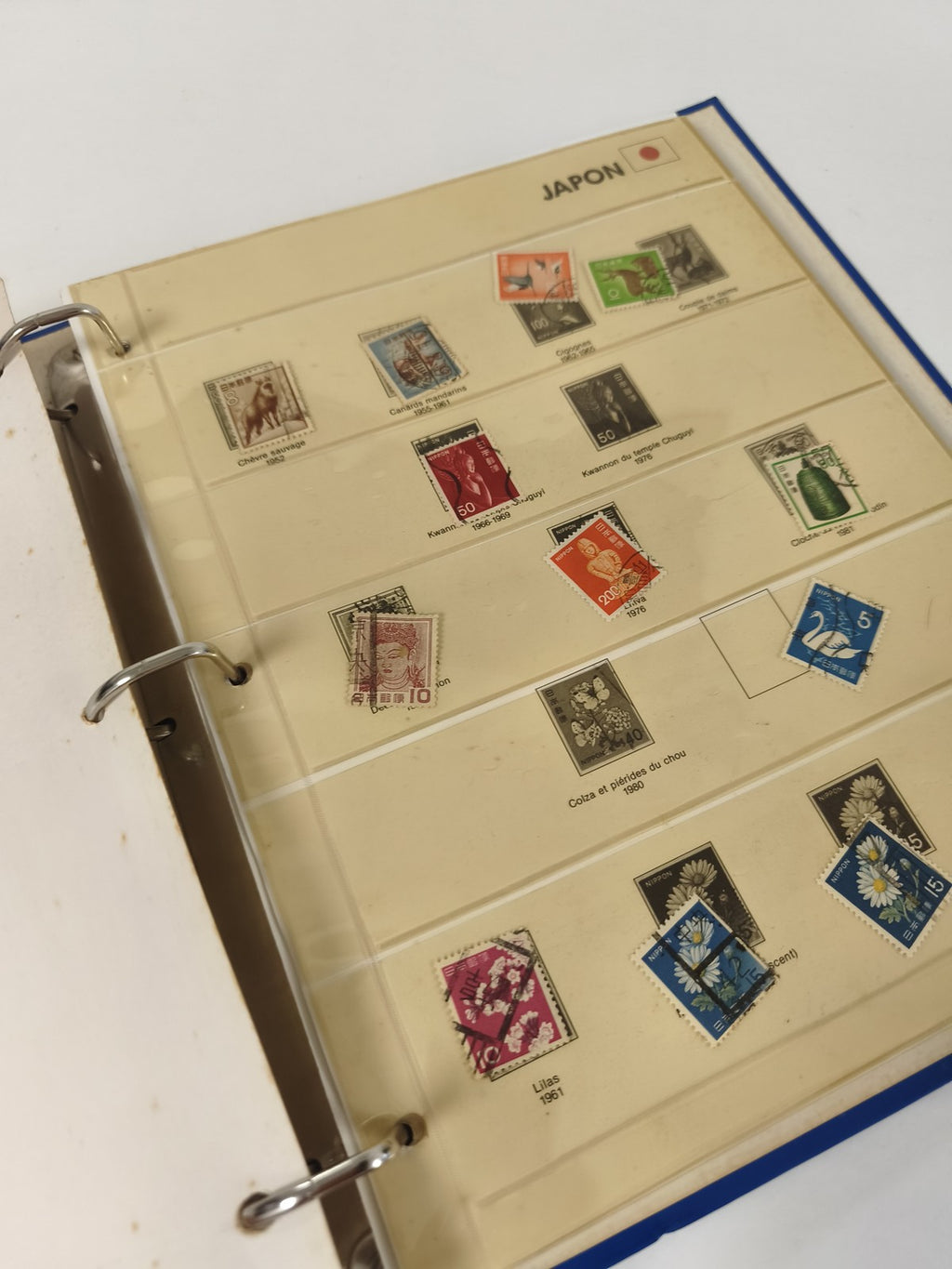 Classeur de timbres partiellement rempli, pages thématiques Japon, reliure bleue