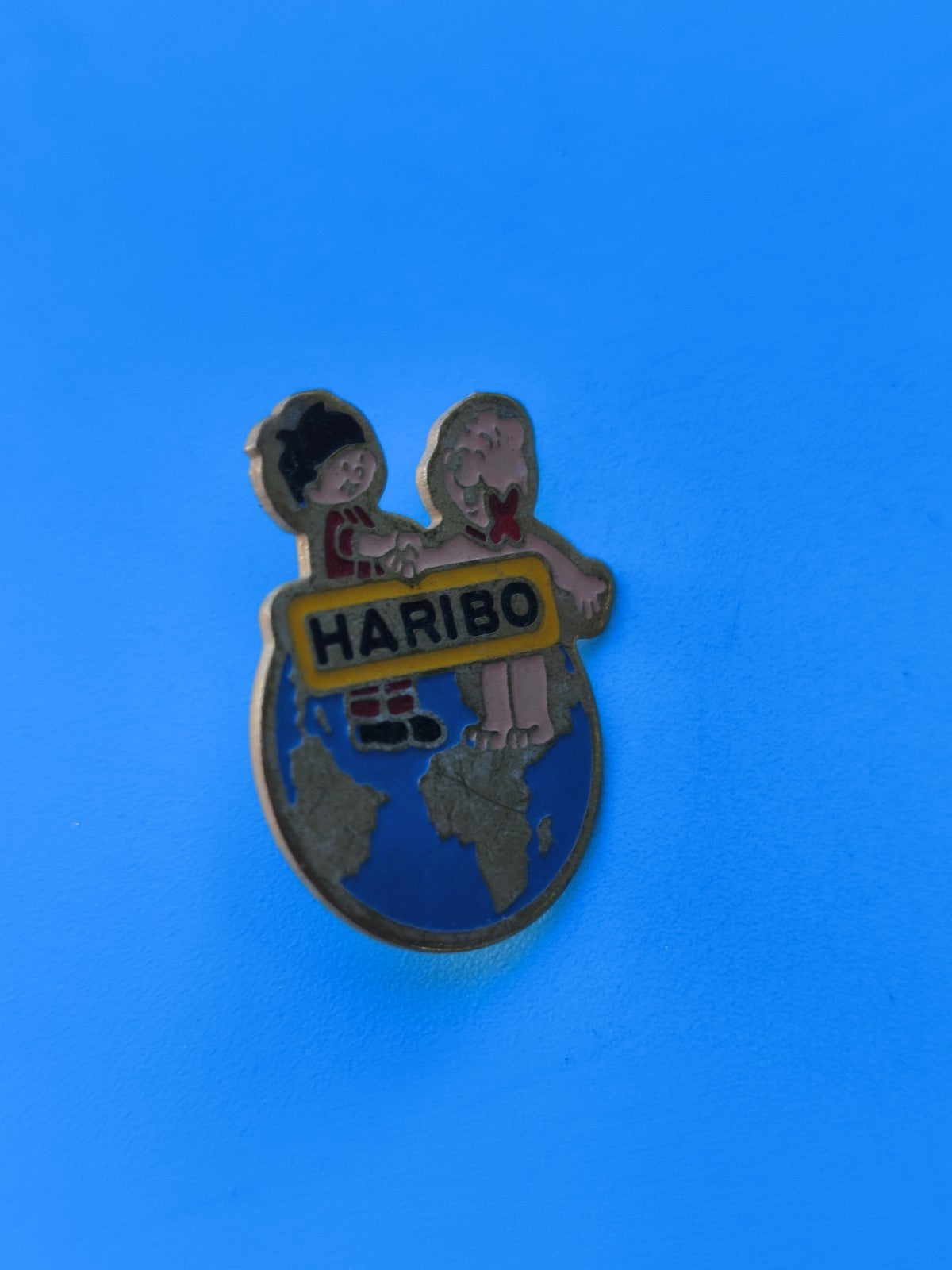 Pin's vintage Haribo enfants sur globe, collection publicitaire ancien