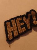 Écusson brodé ancien HEY! doré noir patch vintage textile thermocollant