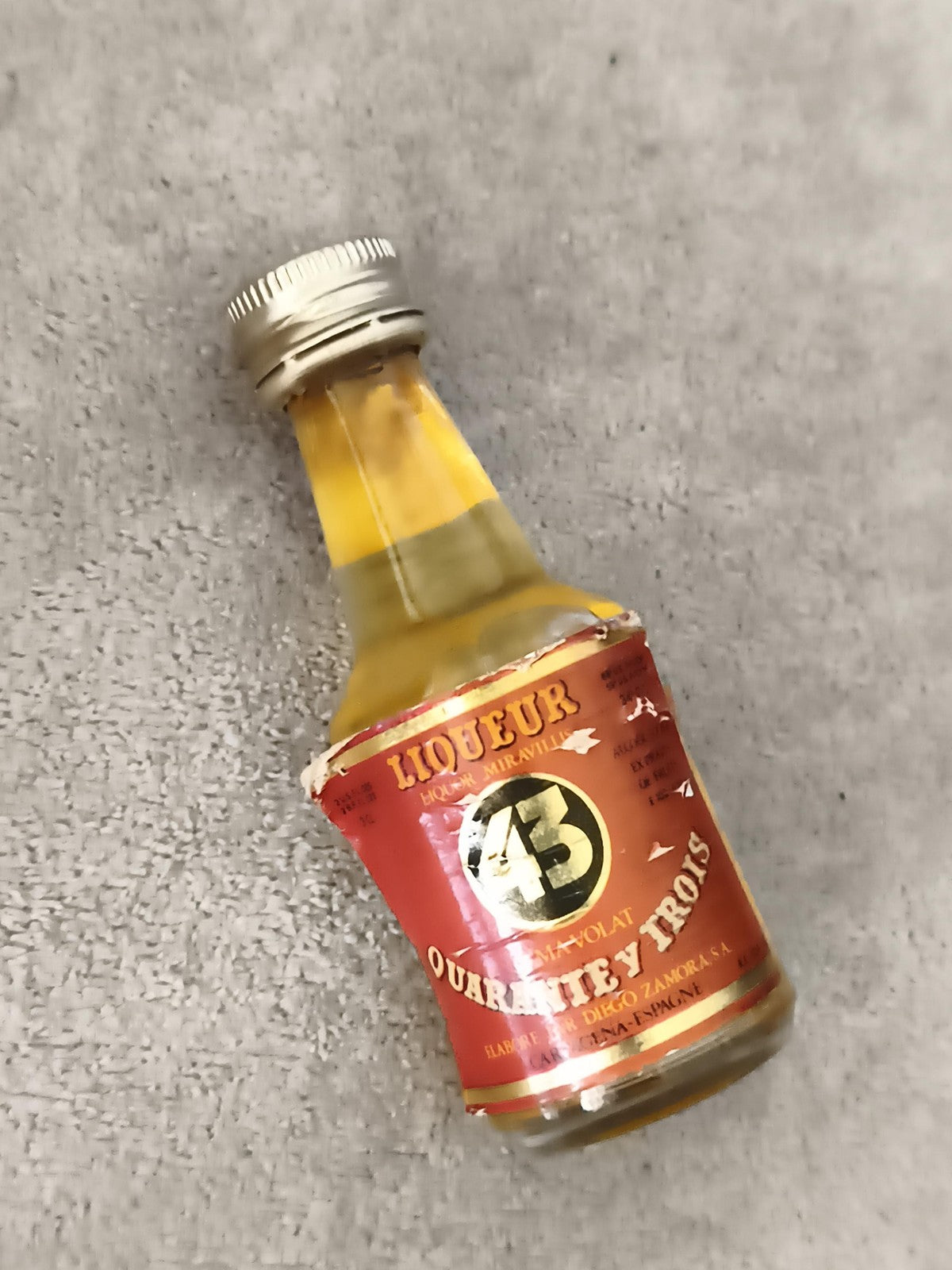 Miniature liqueur 43 Quarante Trois partiellement remplie étiquette rouge