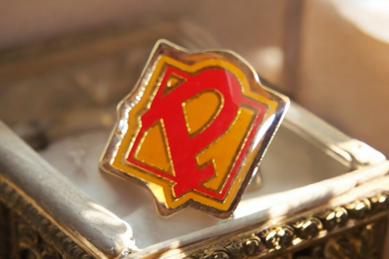 Pin's vintage émaillé rouge jaune, motif graphique rétro, badge ancien