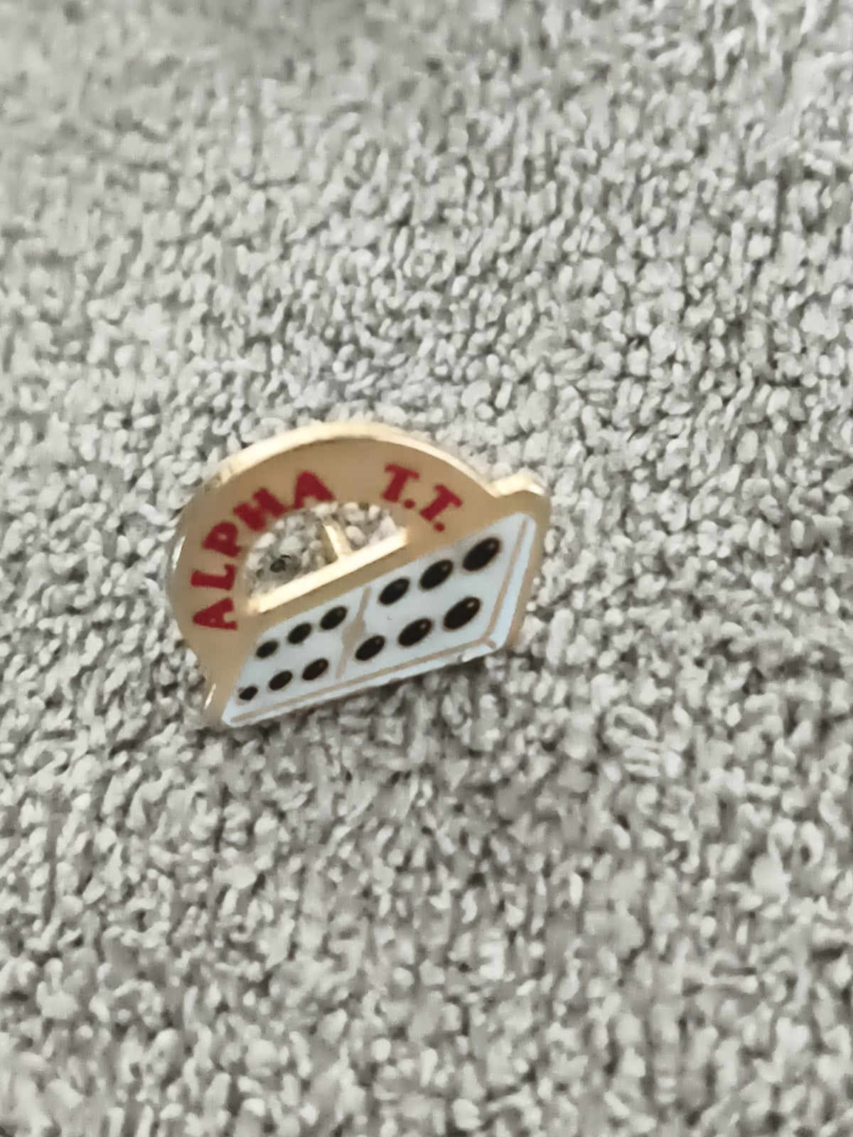Pin's vintage Alpha T.T. motif domino blanc noir ancien badge émaillé rétro