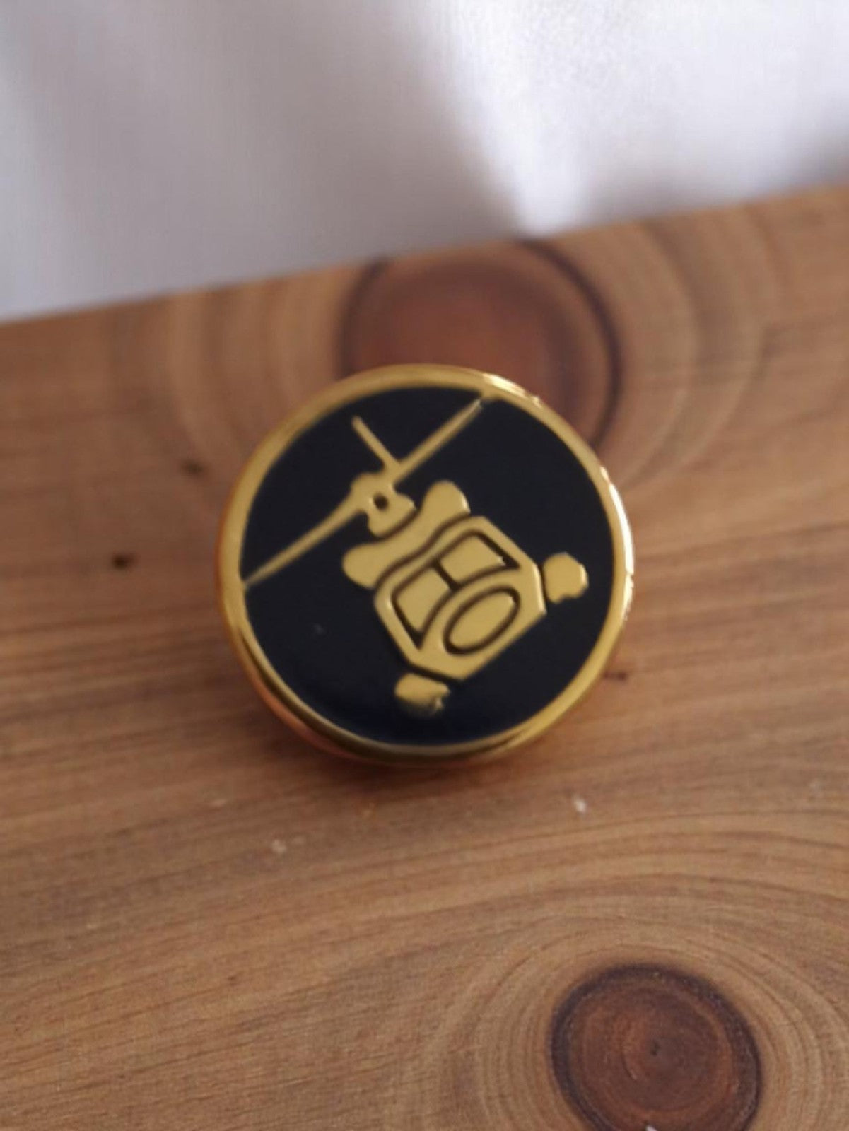 Pin's rond vintage hélicoptère doré sur fond noir rétro accessoire aviation