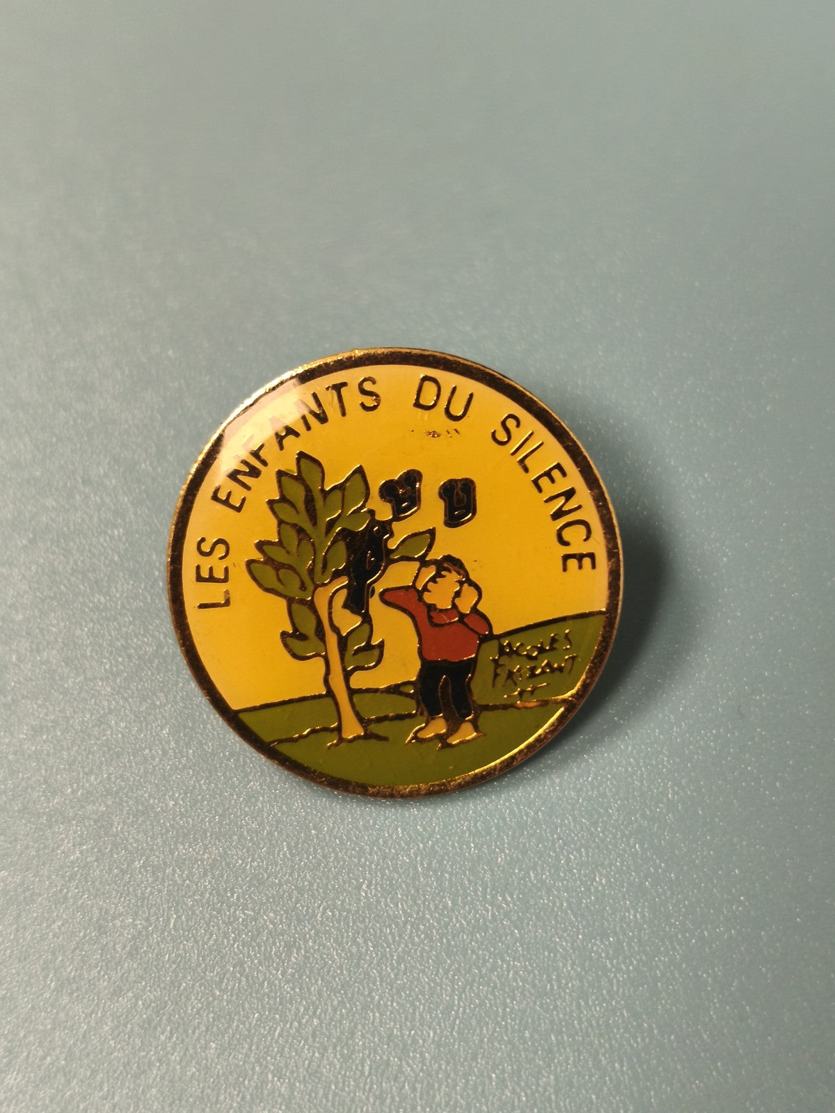 Pin's vintage Les Enfants du Silence rond émaillé jaune illustration enfant (Ref