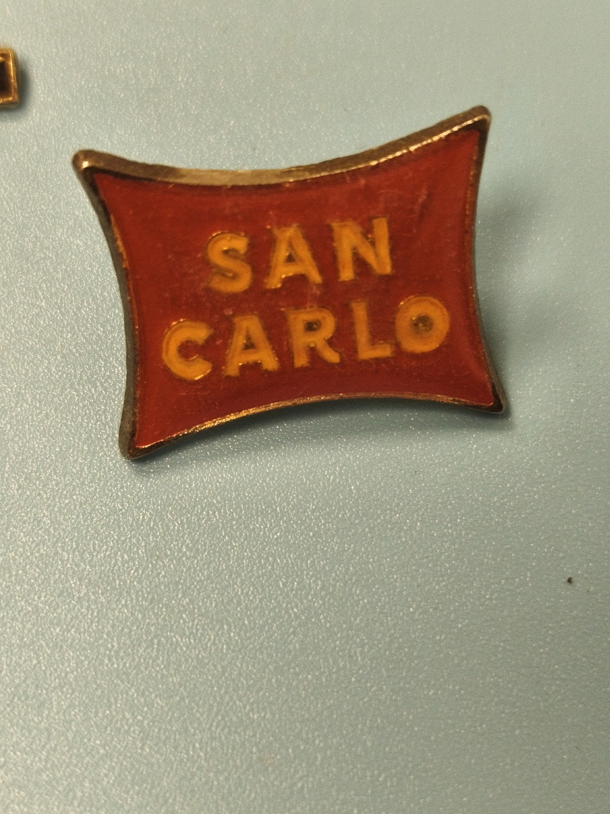 Vintage pin's SAN CARLO rouge forme drapeau ancien collection publicitaire