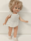 Ancienne poupée blonde aux yeux bleus, robe blanche et corps articulé