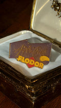 Pin's publicitaire vintage Flodor années 80 ? chips, logo jaune et violet