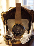 Montre vintage Vertical Paris dorée, bracelet maille, cadran noir rétro à révise