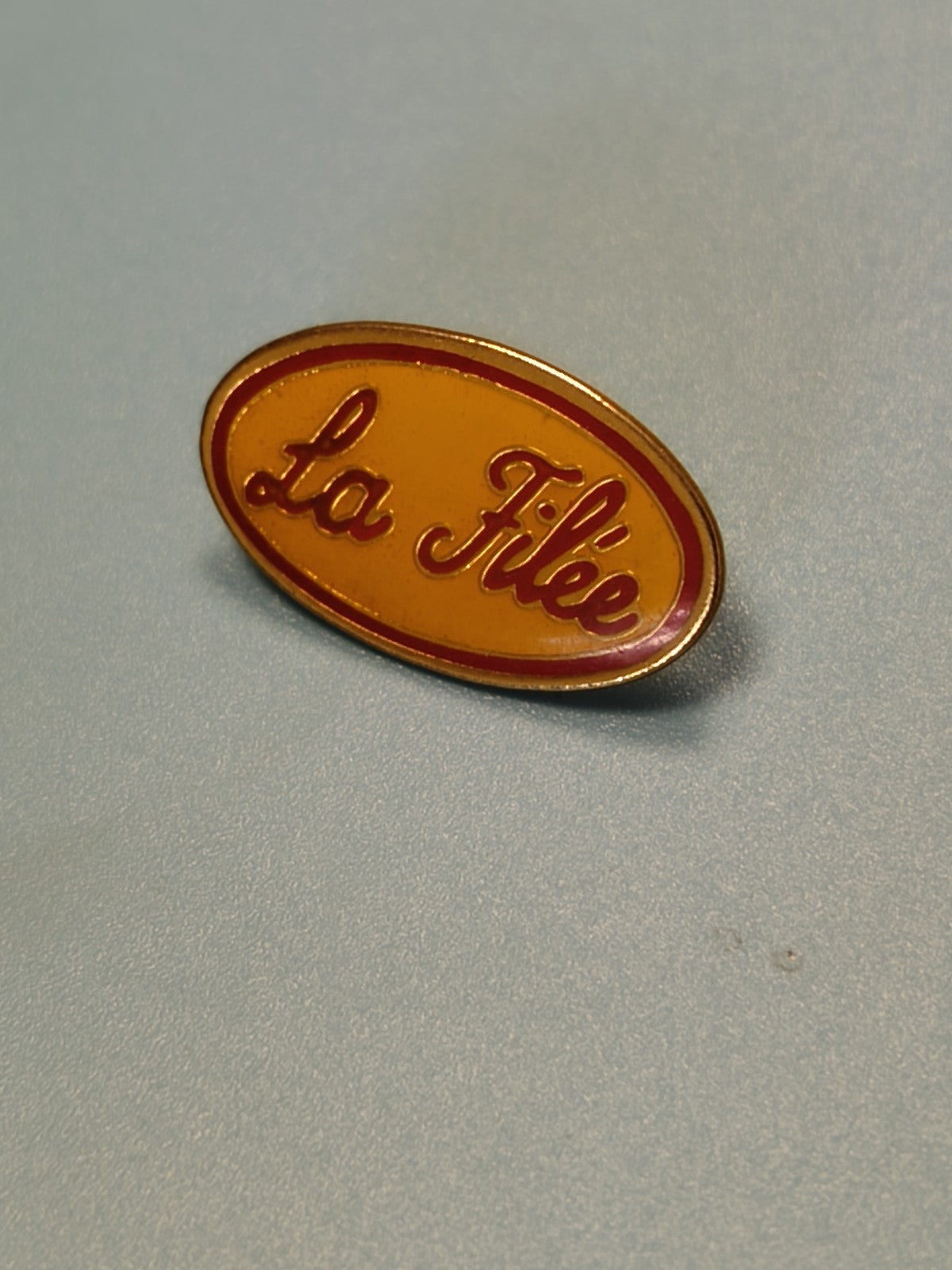 Vintage pin's La Filée ovale orange et rouge ? badge ancien collection