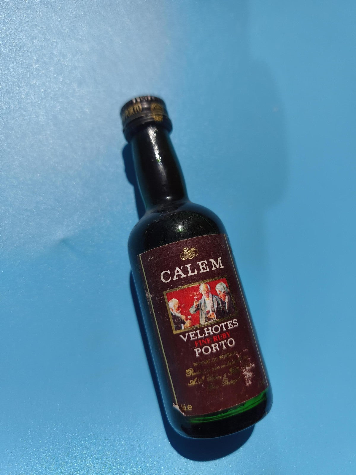 Mignonnette vintage Calem Velhotes Porto, étiquette illustrée, bouteille mi-plei