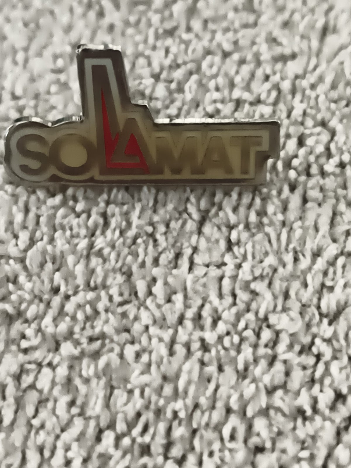 Pin's vintage SOLAMAT logo doré lettrage relief (Ref 7)