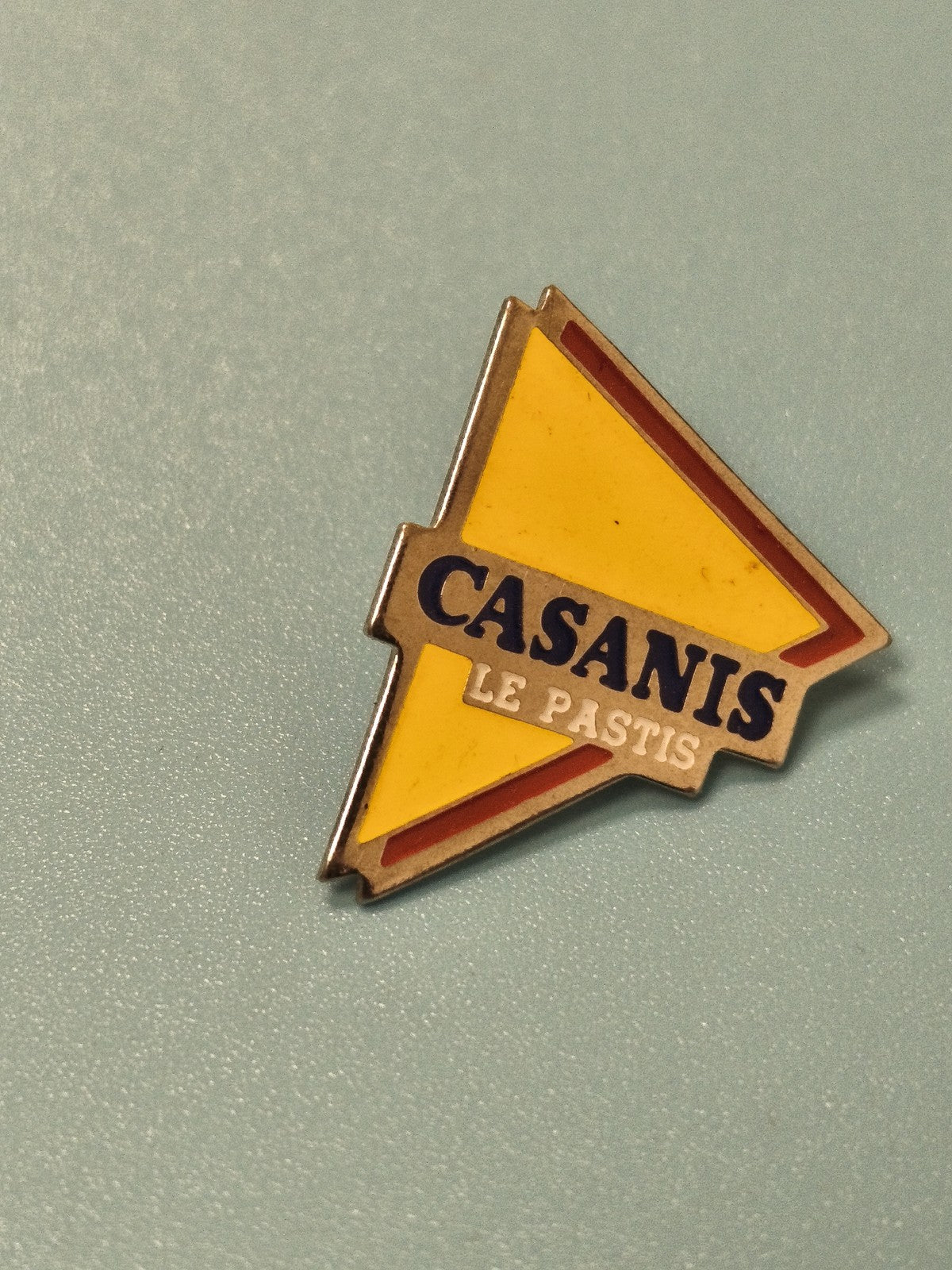 Pin's vintage Casanis Le Pastis triangle jaune publicitaire ancien collection
