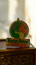 Pin's publicitaire vintage Marius Ferrat paysagiste rare, vert doré ancien