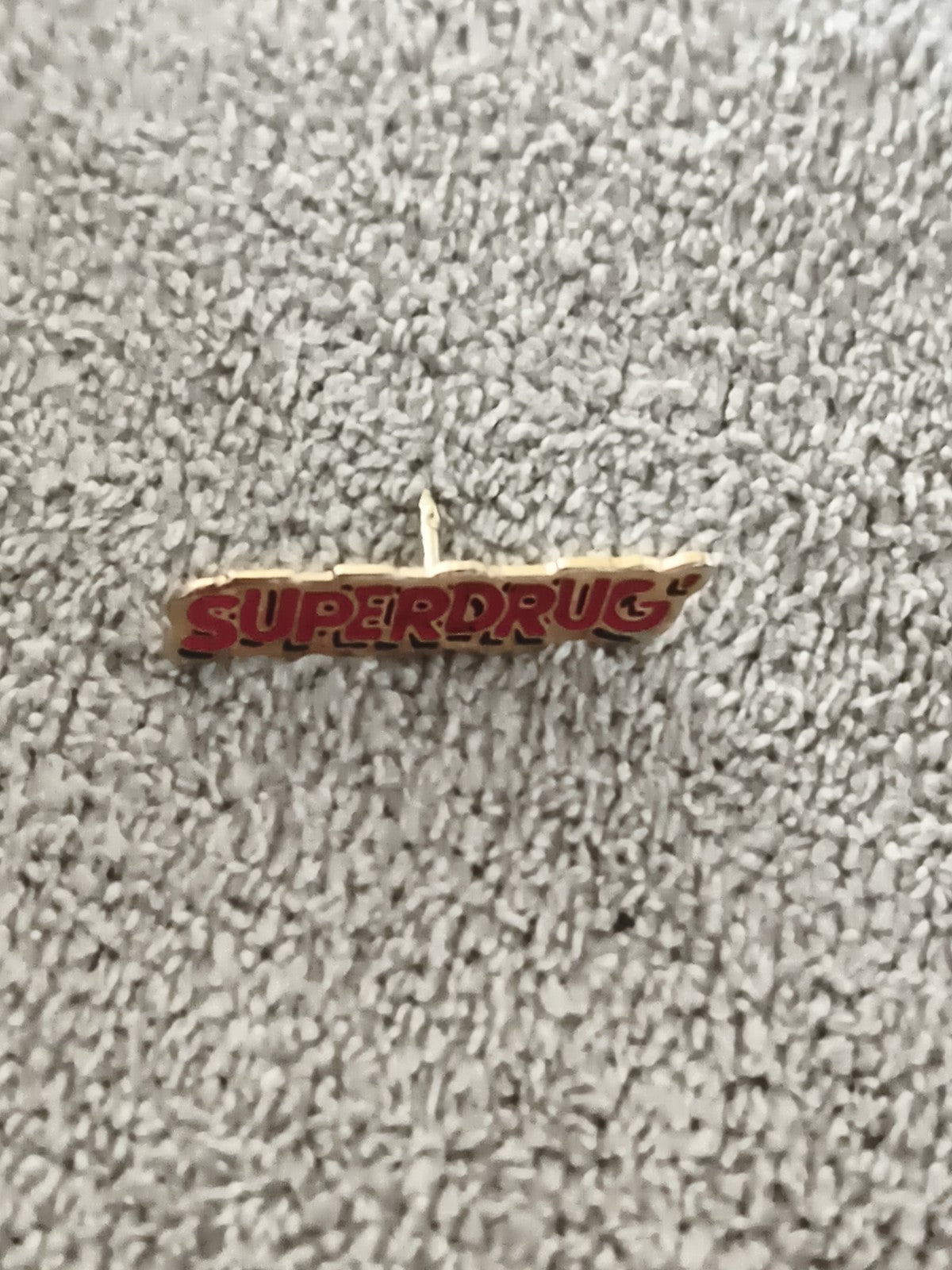 Pin's vintage SUPERDRUG logo, finition dorée, badge publicitaire ancien (Ref 8)