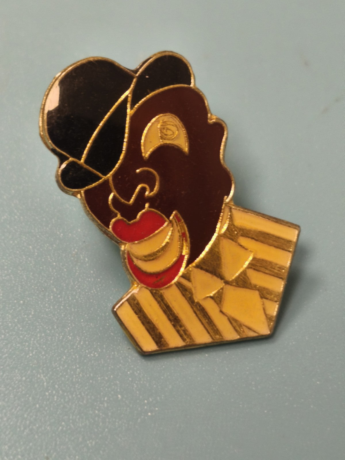 Vintage pin's visage stylisé chapeau noir rayures jaunes émail ancien (Ref 4)