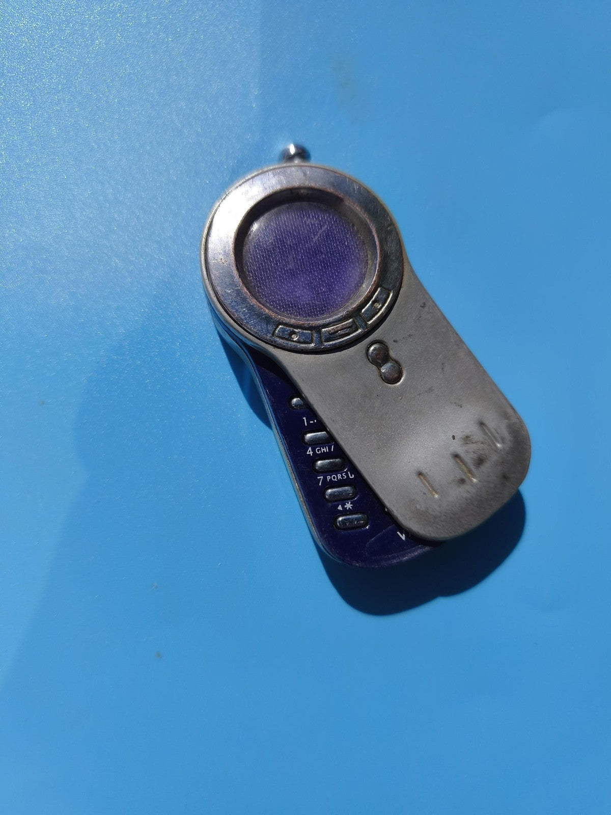 Ancien briquet publicitaire bleu forme téléphone à touches, en l'état vintage