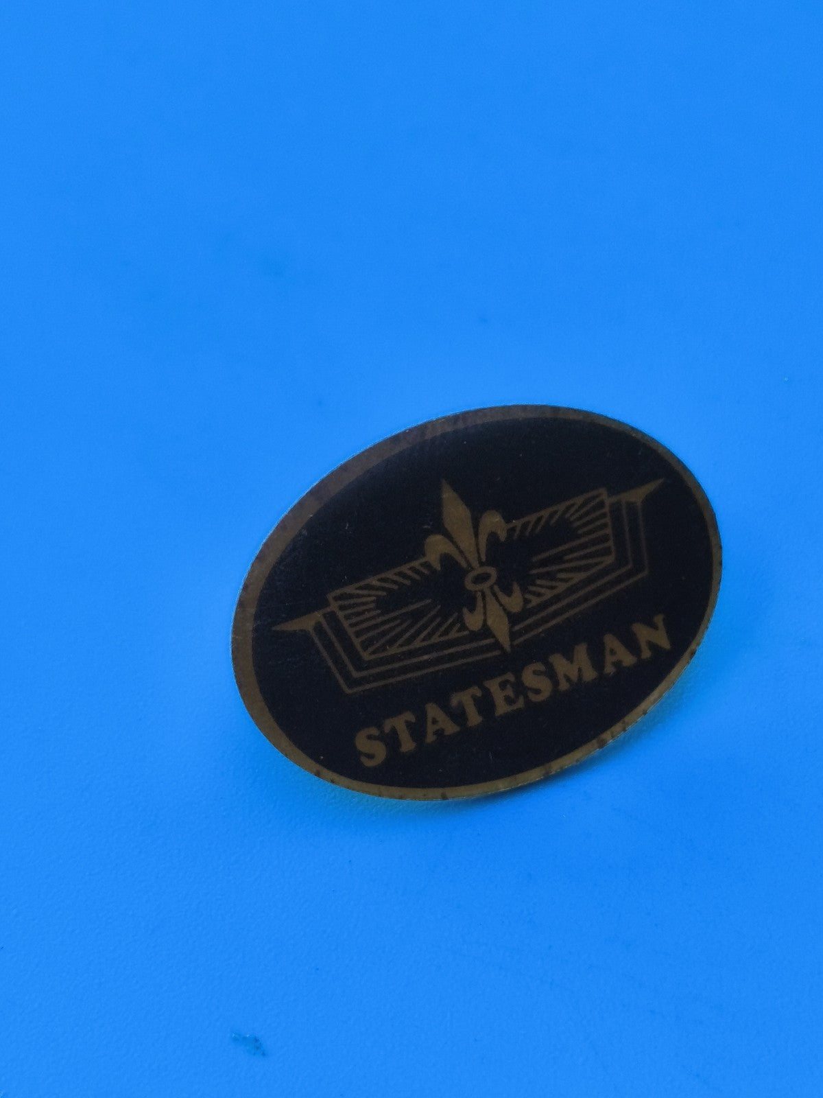 Vintage pin's Statesman ovale noir doré, collection badge ancien rare