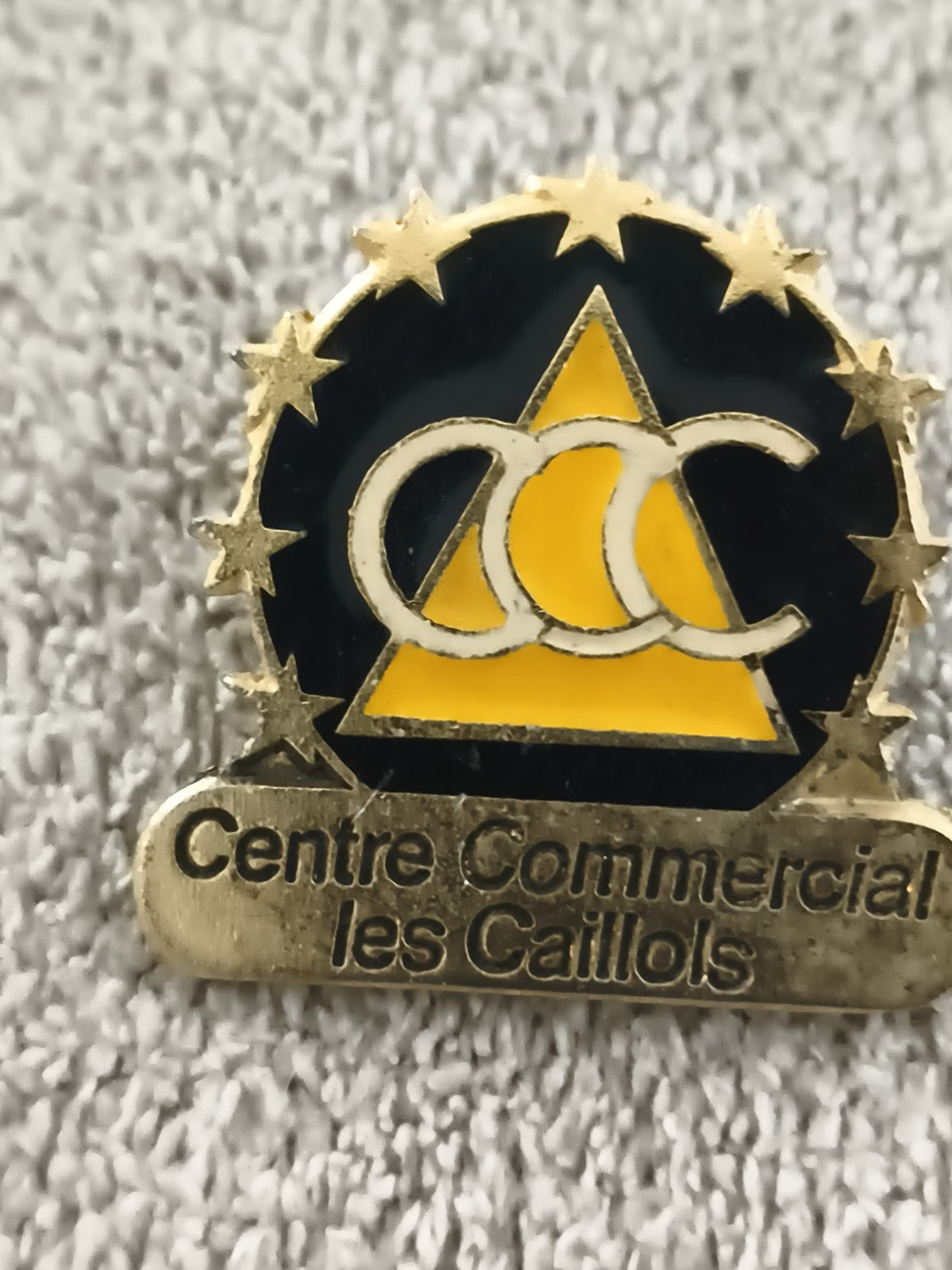 Pin’s vintage Centre Commercial les Caillols logo triangle noir jaune (Ref 4)