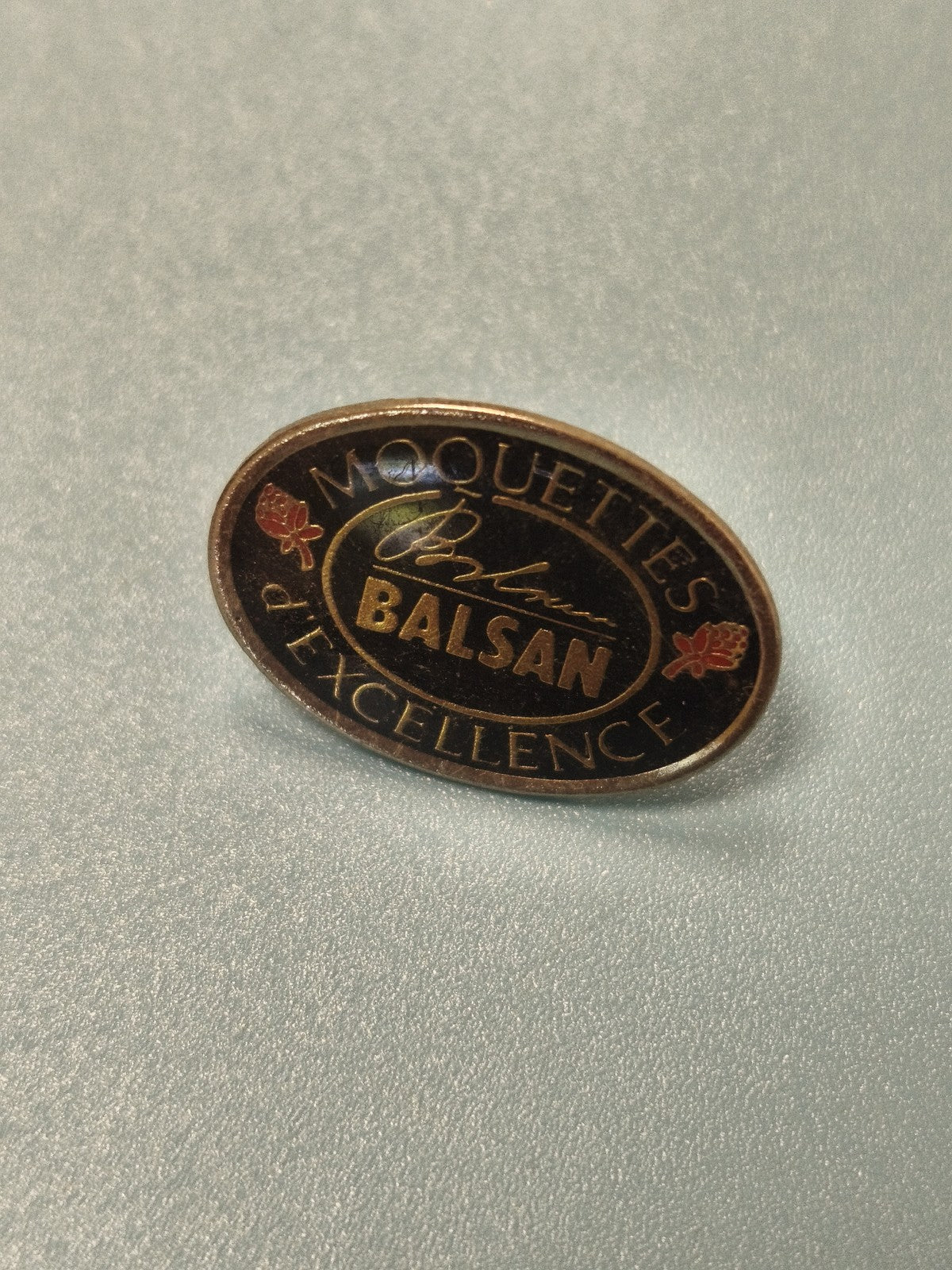 Vintage pin's publicitaire Moquettes Balsan ovale noir doré collection
