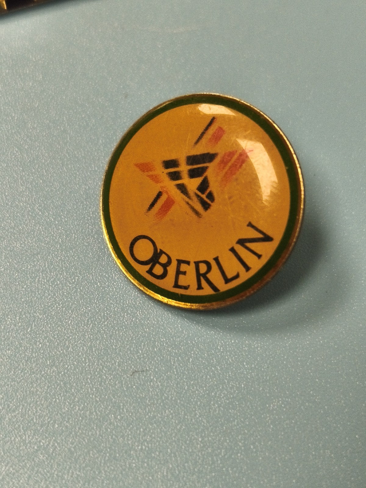 Vintage pin's rond Oberlin jaune logo graphique ancien collection