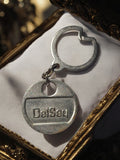 Porte-clés Delsey vintage en métal argenté logo relief, accessoire rétro