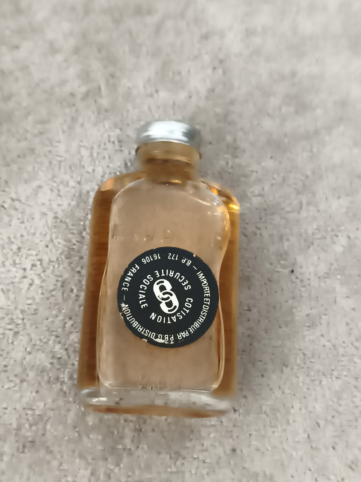 Miniature alcool bouteille Securite Sociale France partiellement remplie