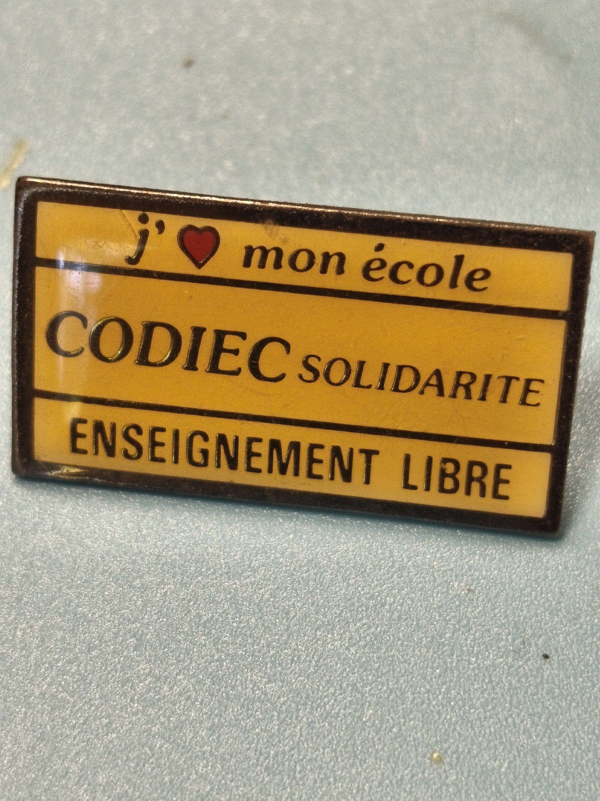 Vintage pin's CODIEC solidarité enseignement libre jaune rectangulaire (Ref 18)