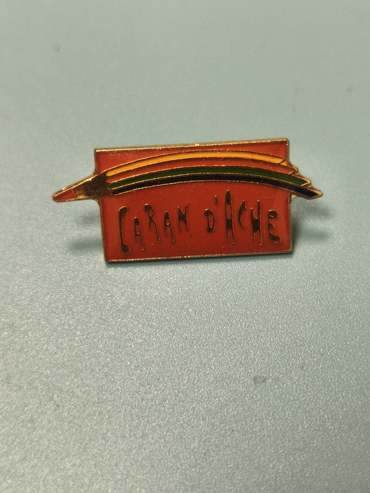 Pin's vintage Caran d'Ache rouge arc-en-ciel logo ancien collection (Ref 17)