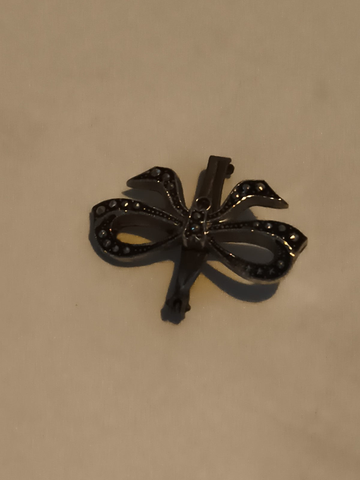 Broche vintage nœud strass aspect métal foncé, bijou rétro pin’s ancien