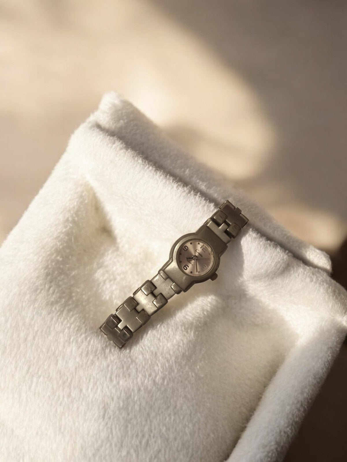 Montre femme vintage à remontoir, bracelet maillons aspect métal, ancienne rétro
