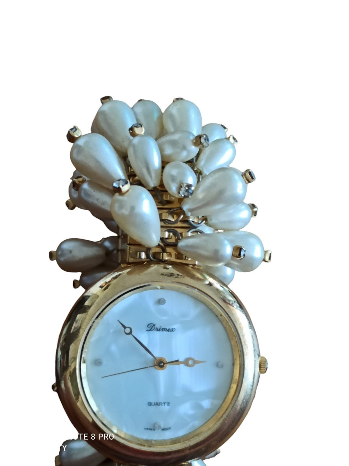 Montre femme Drimex bracelet perles nacrées doré cadran blanc élégant
