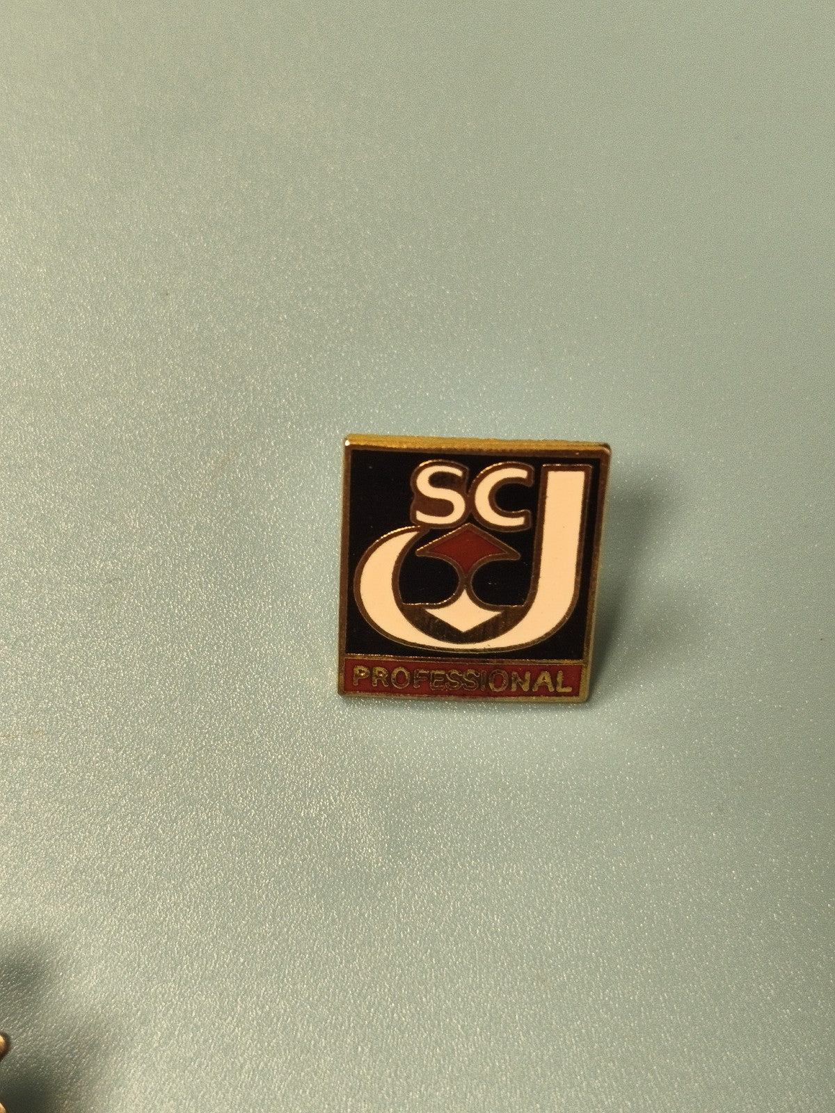 Vintage pin's SCJ Professional carré émaillé noir blanc rouge ancien (ref 11)