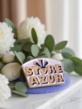 Pin's publicitaire vintage émail Store Azur – badge rétro bleu doré